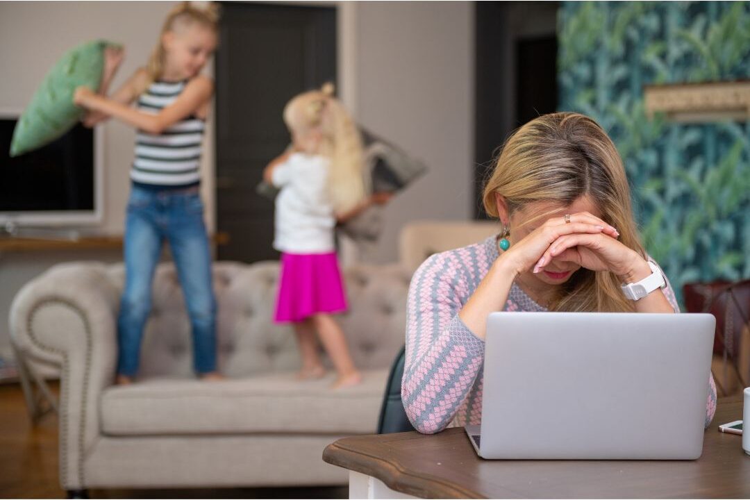 exhausted mom sitting at kitchen counter recognizing the 10 warning signs you're headed for mom burnout