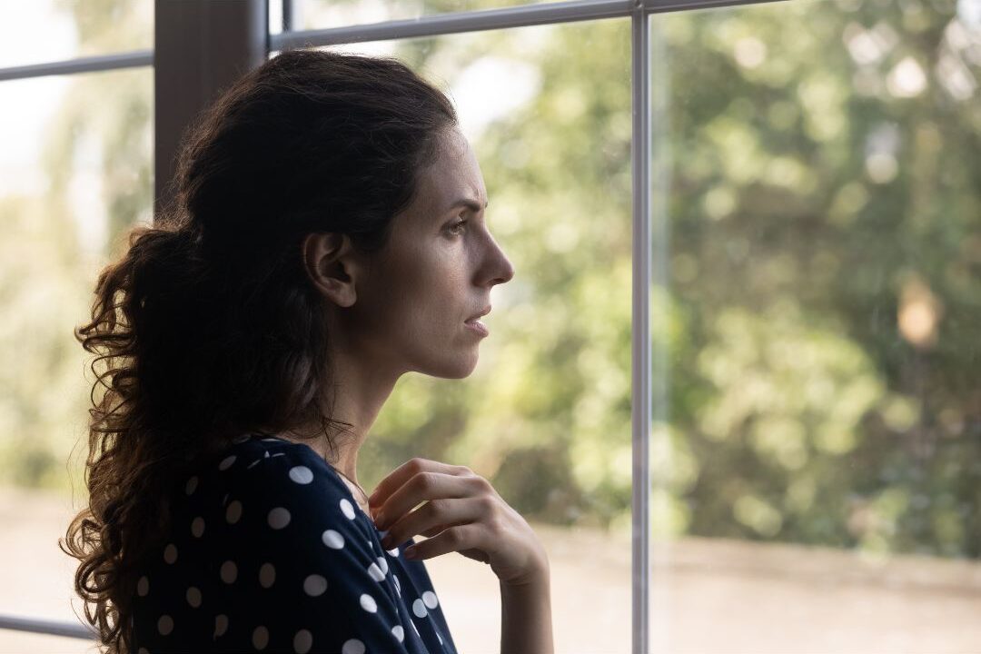 stay at home mom looking out the window using affirmations on days she questions her choice