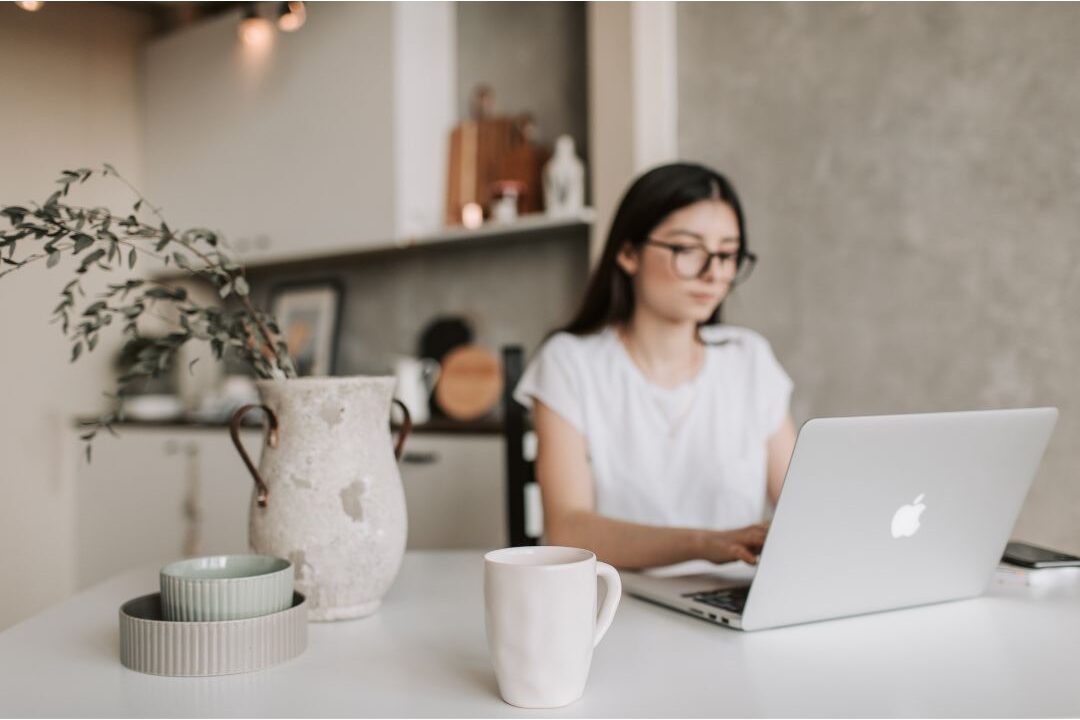 a focused mother working on her laptop balancing ambition with soft living