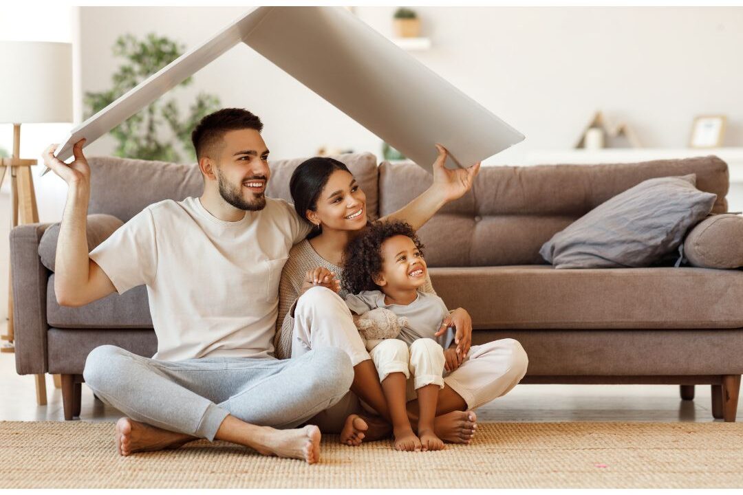 happy family hugging while sitting together on their comfortable living room floor