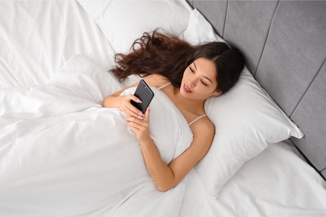 woman checking her phone in the morning one of the habits secretly keeping her stressed