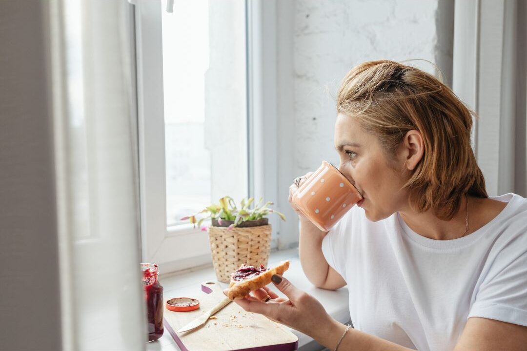 woman enjoying a silent morning cup near a window practicing daily micro rest