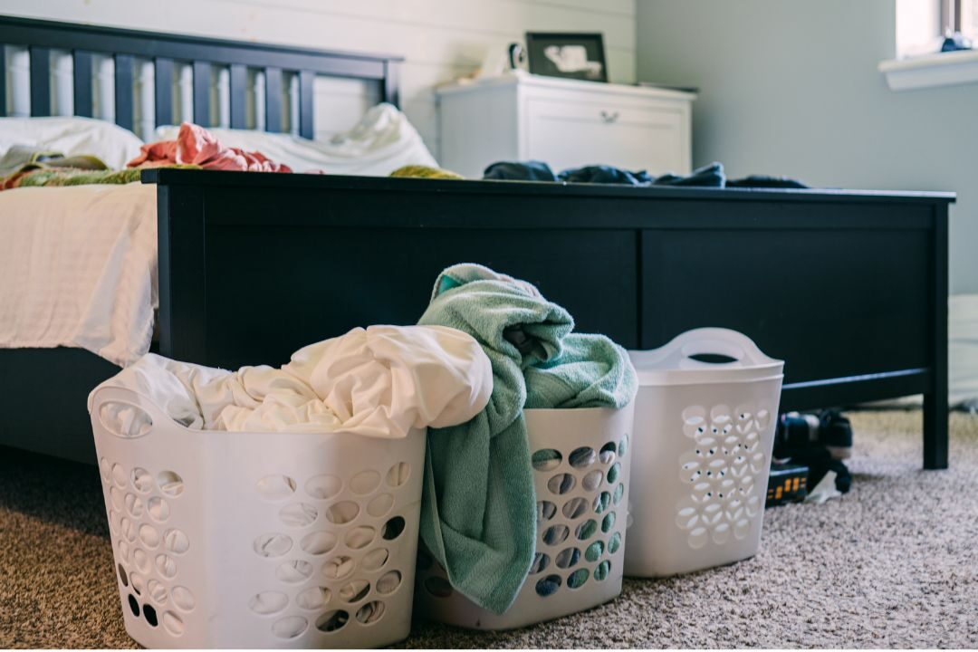 cleaning a washing machine to fix one of the laundry related reasons why a home always smells bad