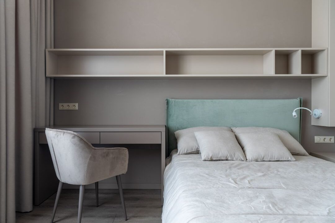 desk behind bed setup creating visual division in a small bedroom