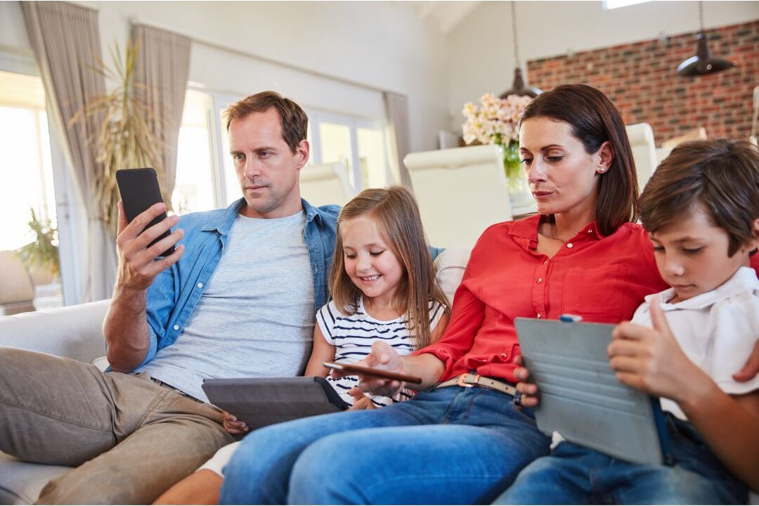 family members sitting together but distracted by their individual smartphone screens