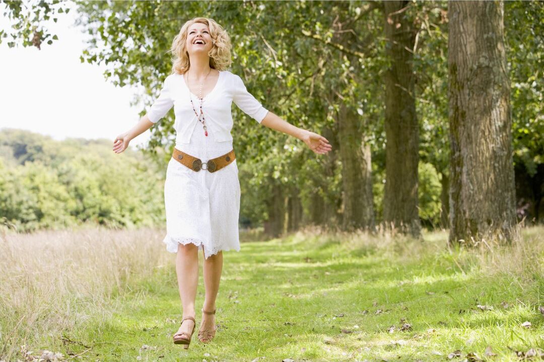 smiling woman walking down a clear path embracing her current season of motherhood