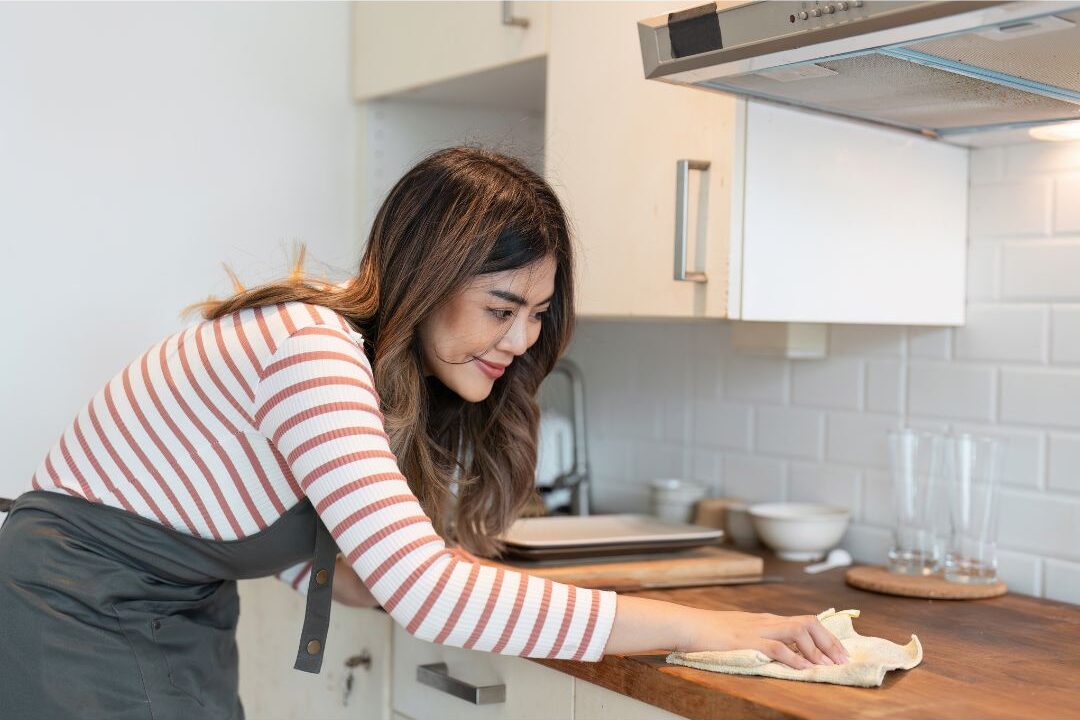 wiping the stove while warm to keep the house clean