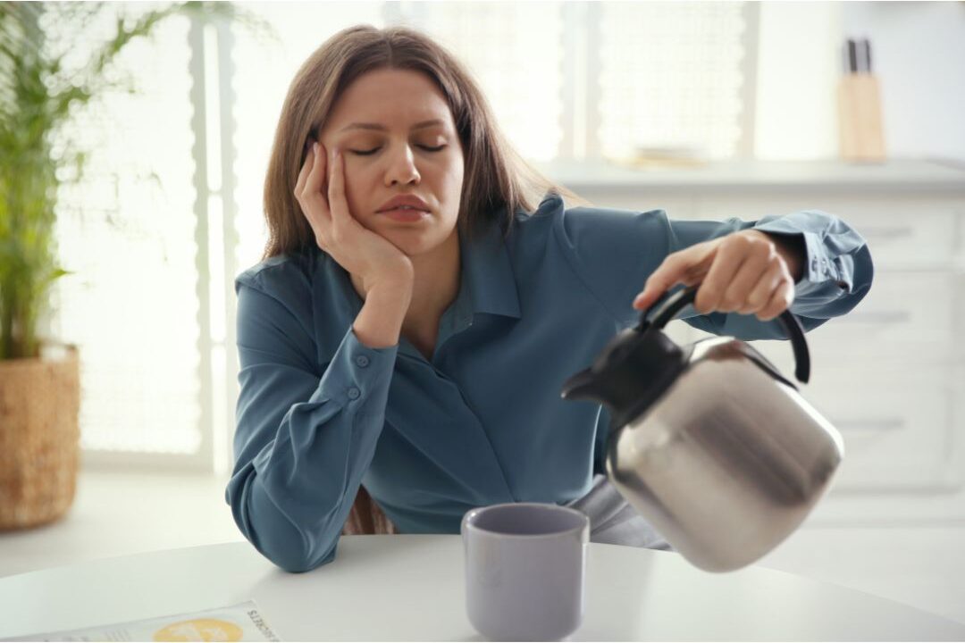 tired mom sitting at kitchen table acknowledging emotional fatigue is a reason your kitchen never stays clean