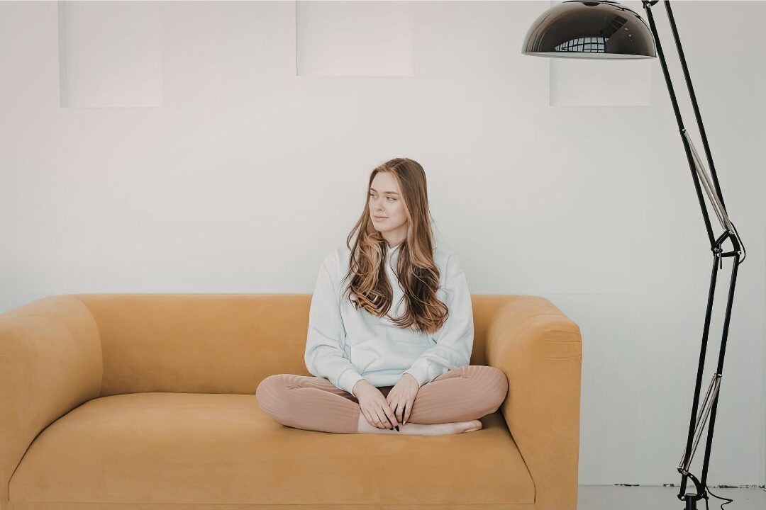 peaceful mother sitting on a couch embracing her authentic life