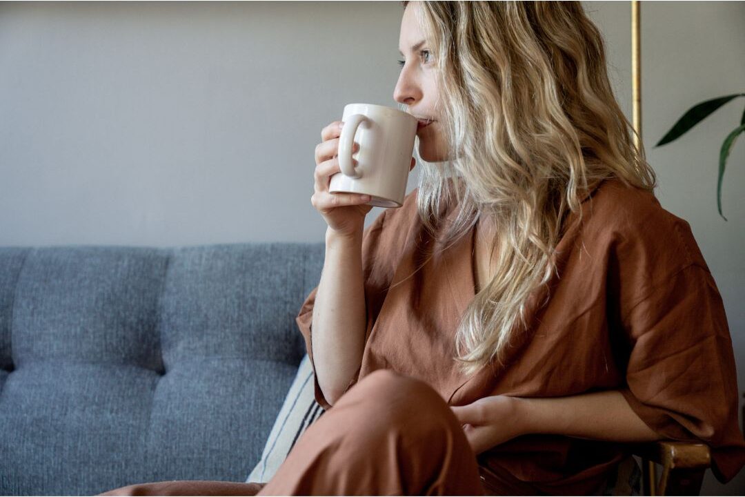 woman sipping a warm drink outdoors taking a low input micro pause