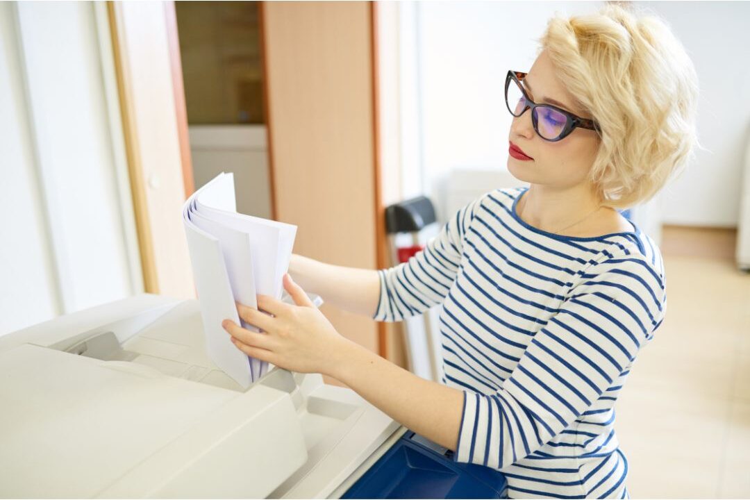 woman sorting through mail paper on a kitchen island to eliminate visual clutter