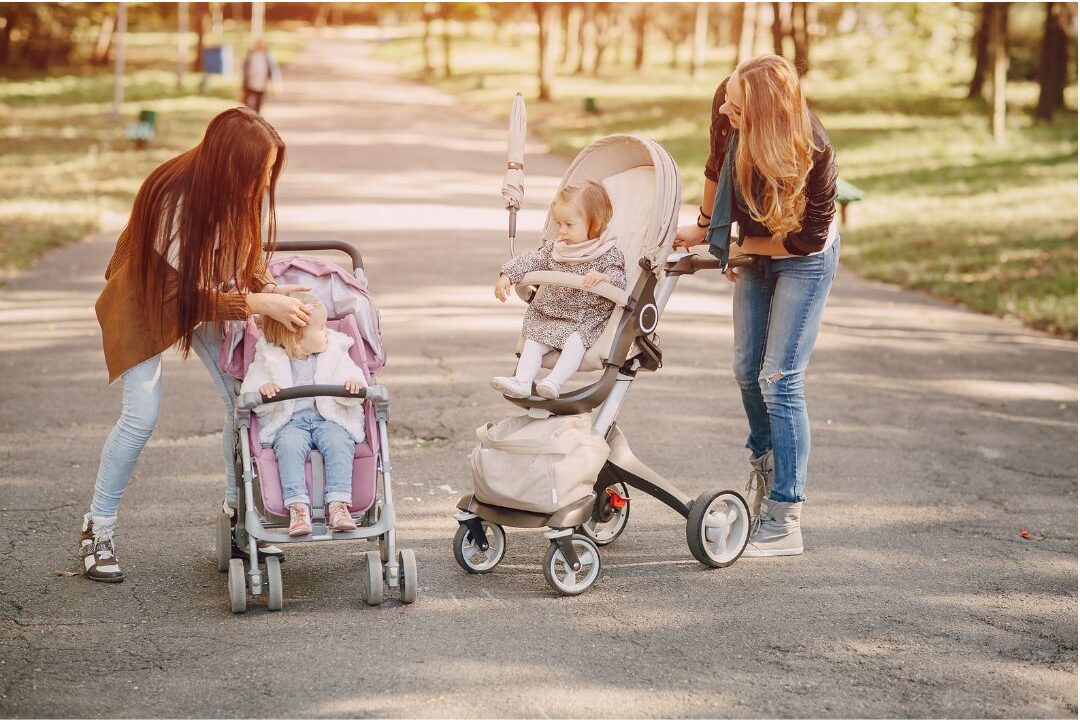 two mothers talking openly over a walk while their children play nearby
