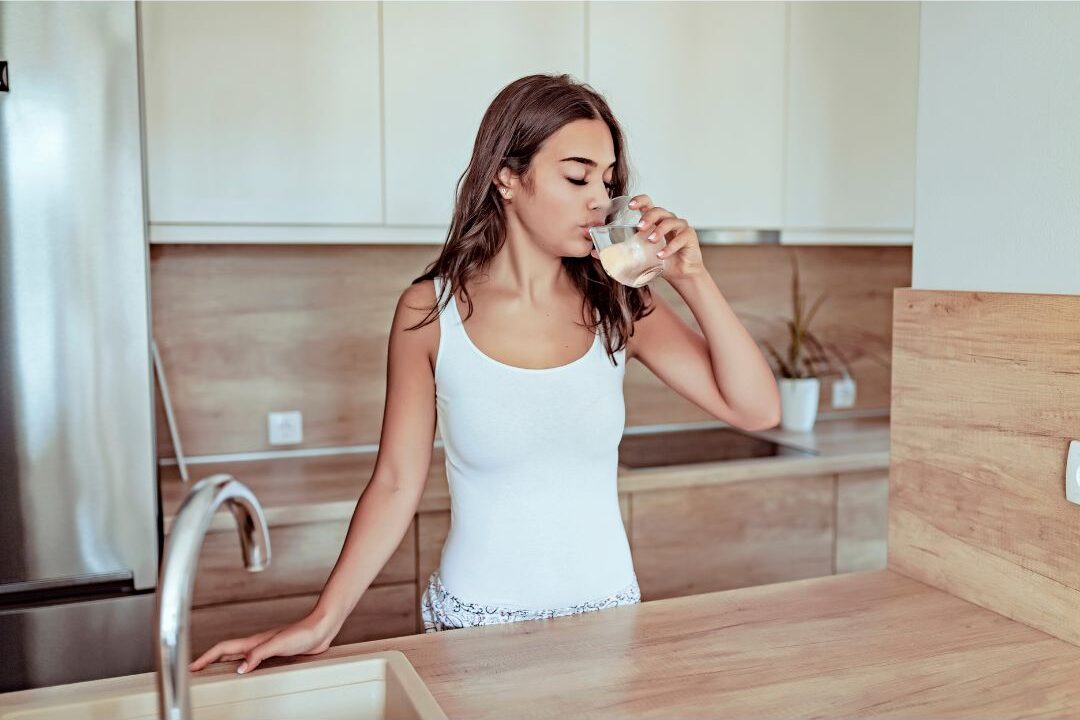 woman drinking water as part of her free morning self care habit