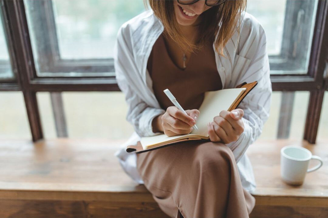 stay at home mom tracking her morning routine habits in a notebook