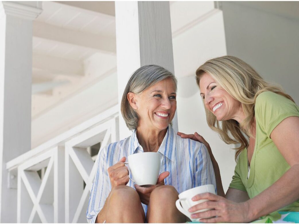 multi generational female friends talking together on a sunny porch