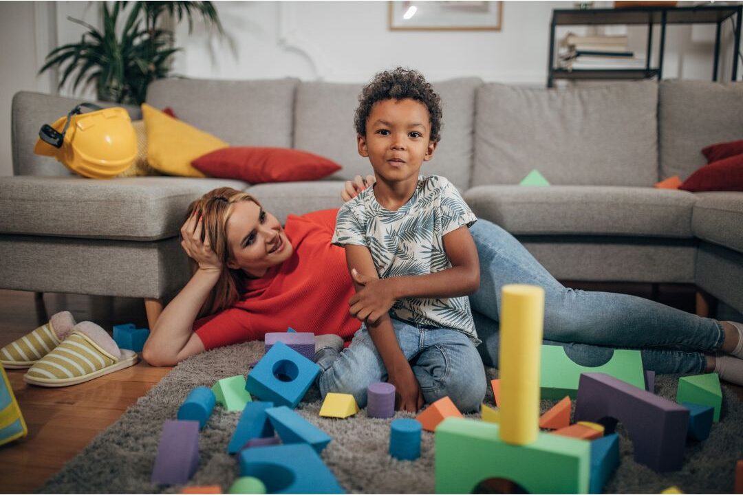 mother laughing and playing with her child in a realistic living room with smart toy storage
