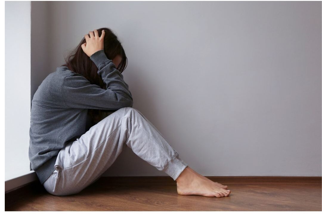 sad mother sitting alone in living room caught in a guilt cycle