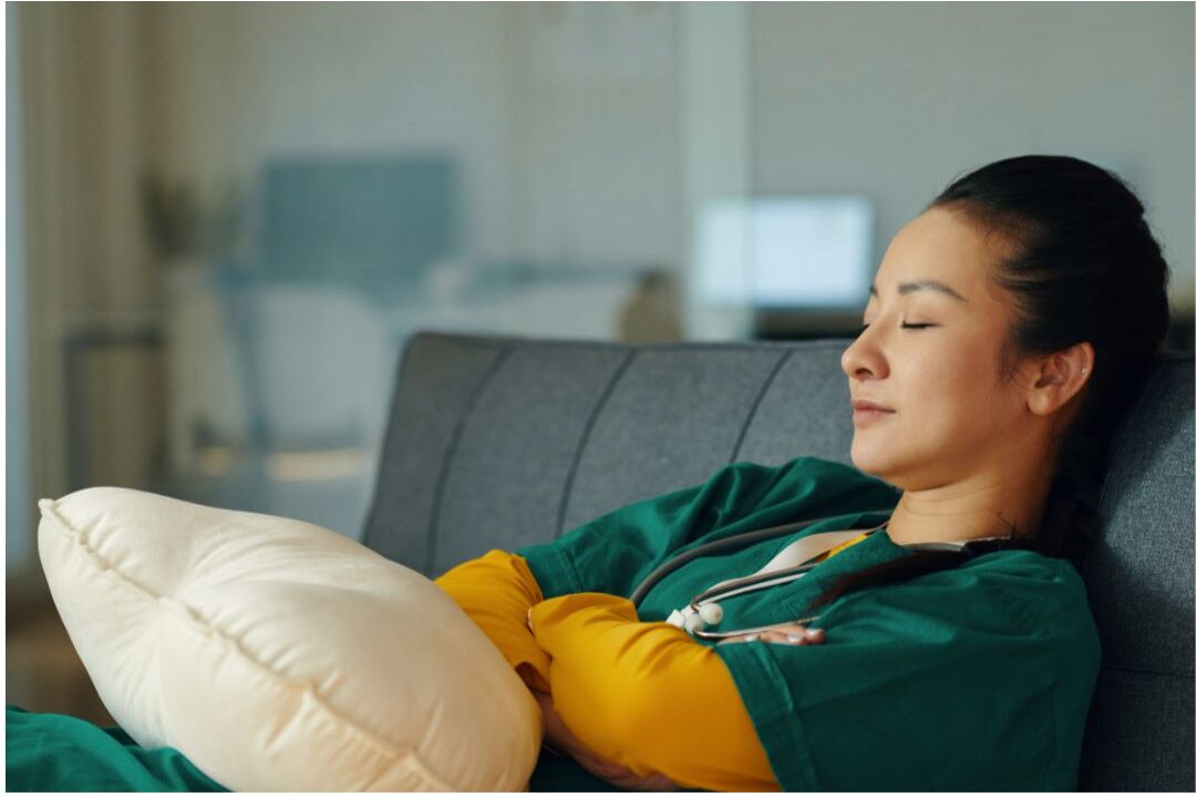 woman sitting in a quiet dark room with eyes closed regulating her nervous system