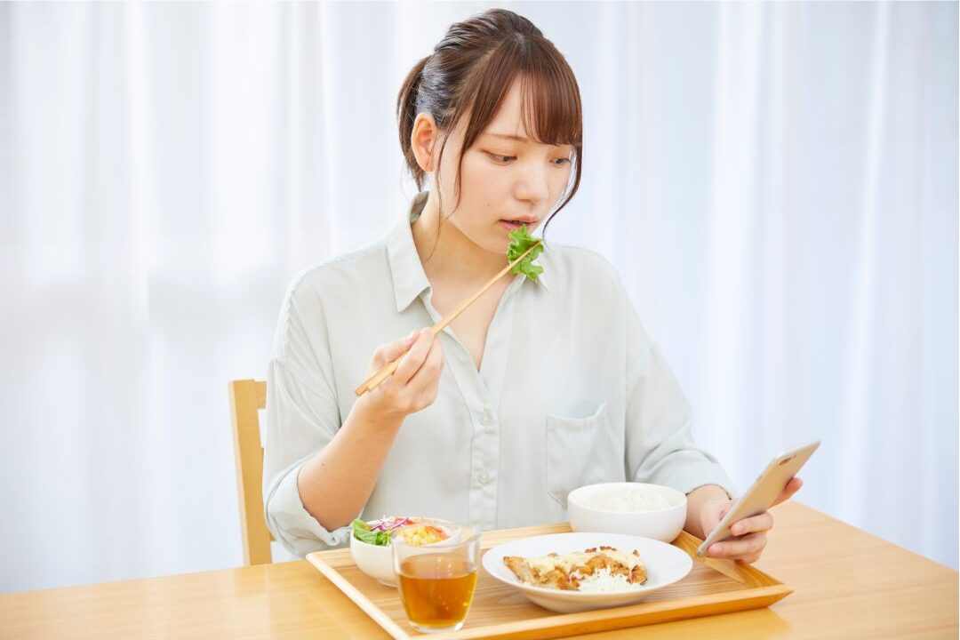 woman eating while distracted one of the habits secretly keeping her stressed