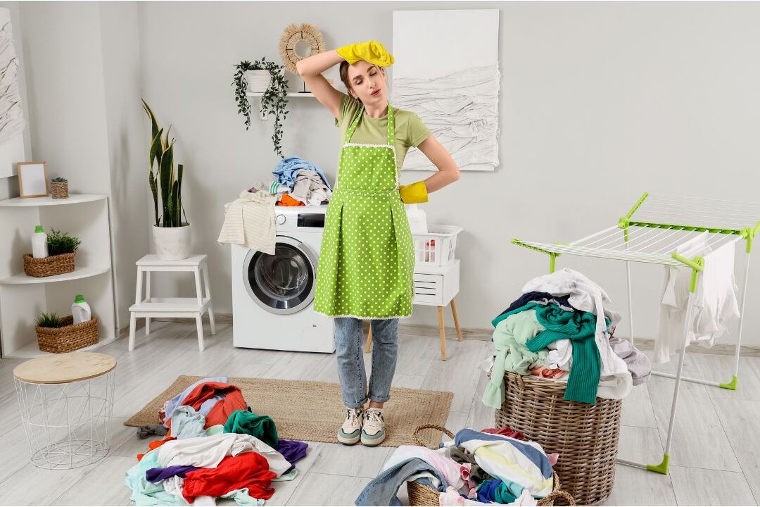 overwhelmed woman looking at a messy laundry suffering from systemic household overload