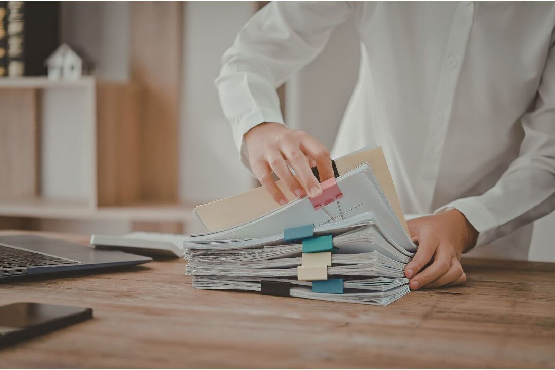 person neatly organizing family financial documents and investments in a binder