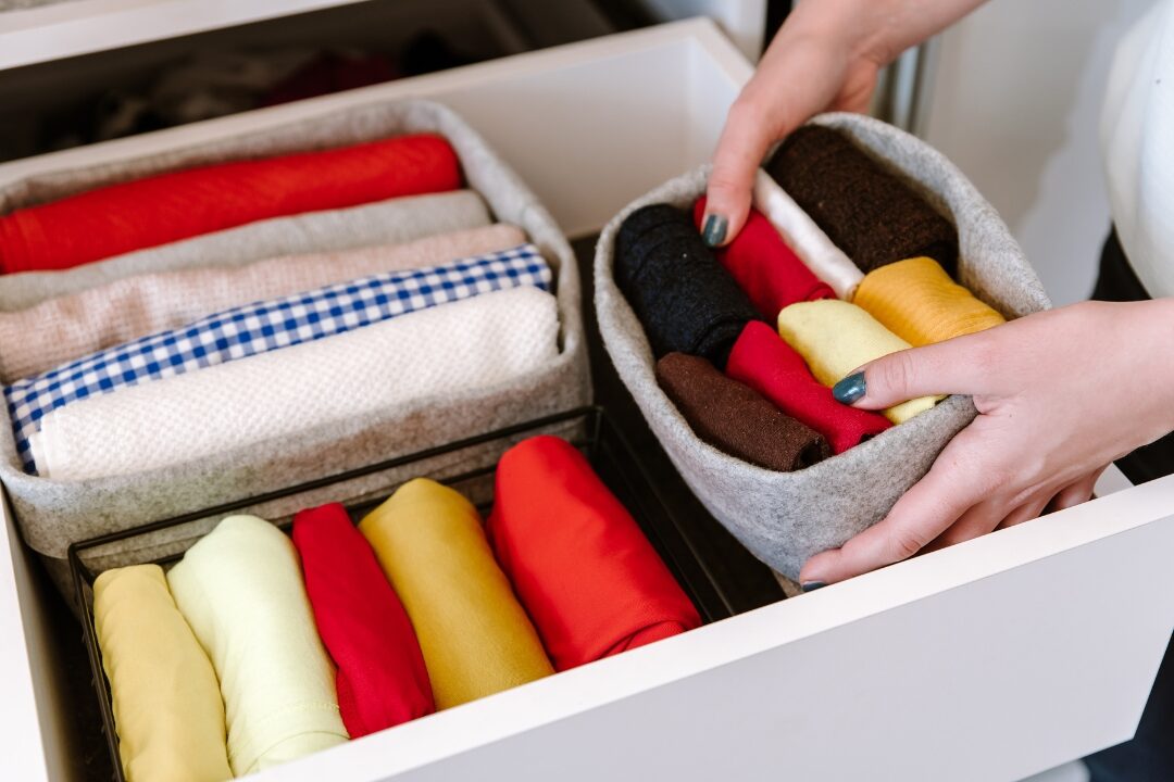family member placing folded clothes into bedroom drawer learning responsibility