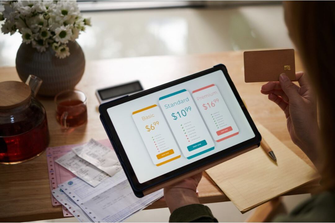 woman auditing monthly subscription bills on her laptop identifying money mistakes stay-at-home moms make