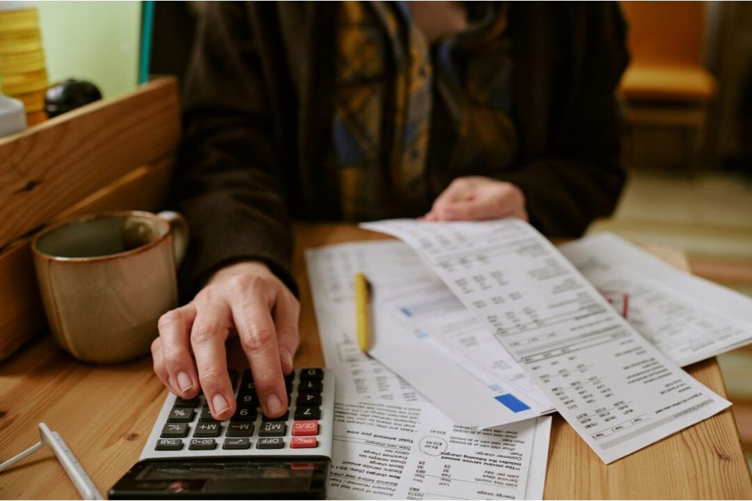 woman reviewing monthly utility and insurance bills at a table