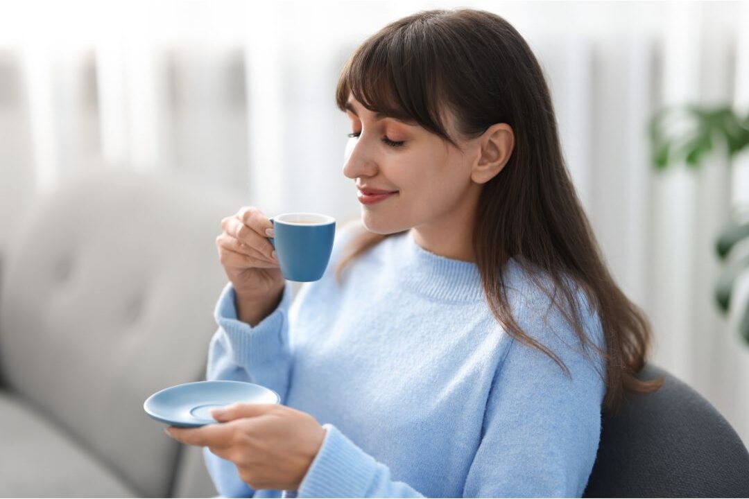 woman relaxing comfortably on a sofa drinking warm tea
