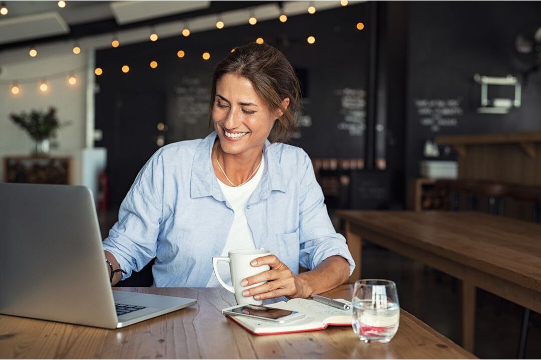 woman smiling calmly while setting up digital schedule on laptop automating home management