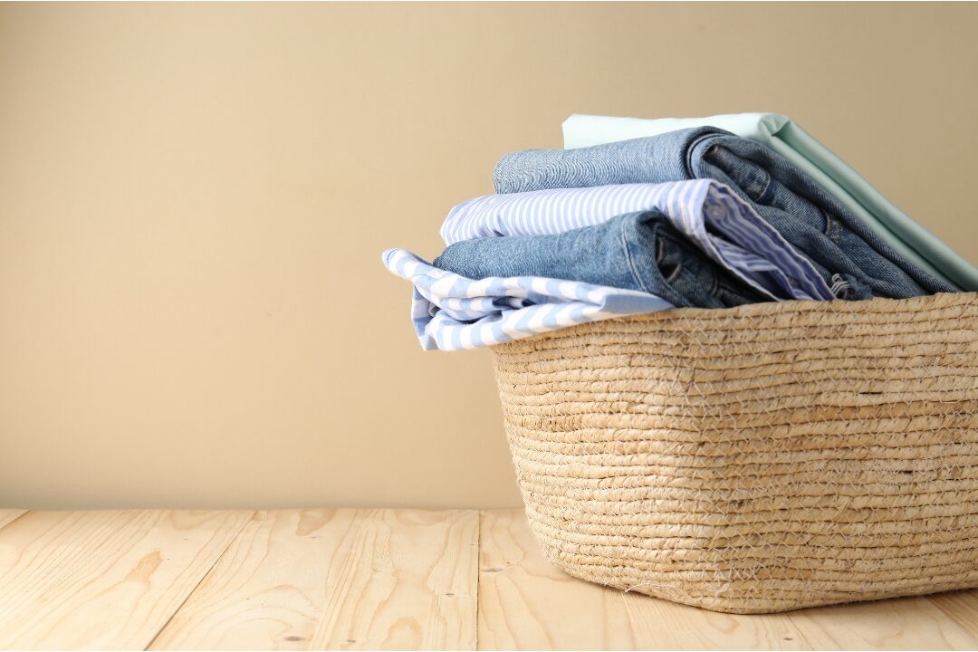 folded clean laundry stacked neatly in laundry basket showing organized home workflow