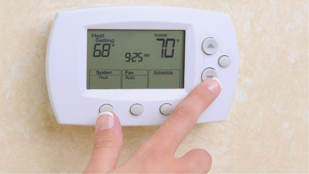 modern smart thermostat mounted on white wall displaying climate automation