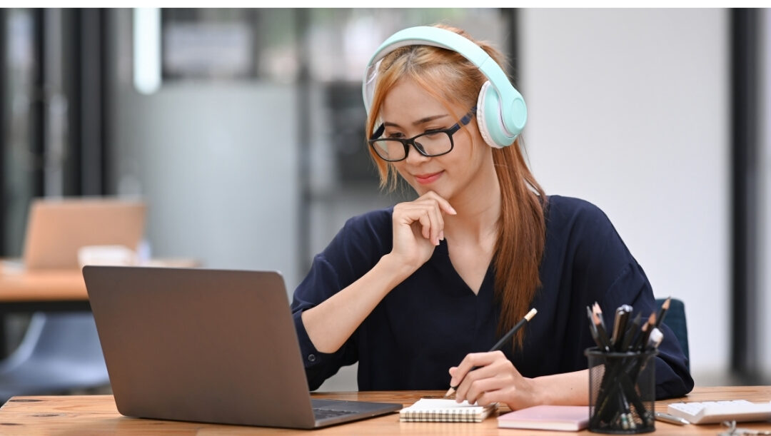 woman wearing headphones working focused at laptop near closed door maintaining clear family boundaries