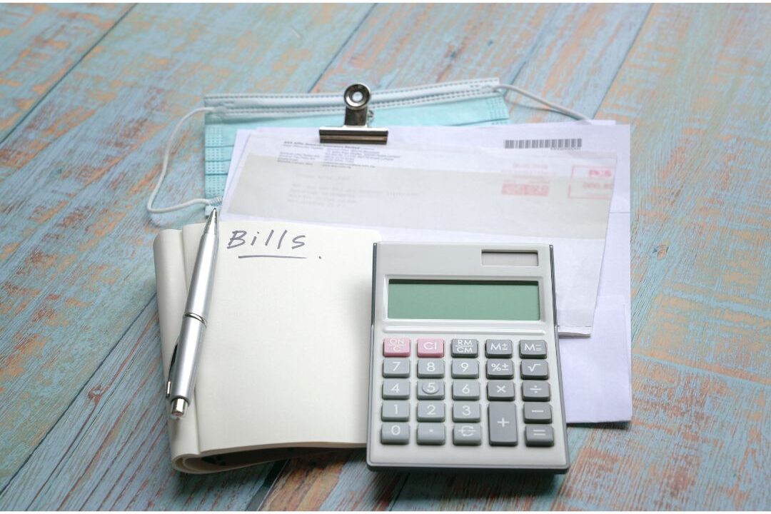 close up of a calculator sitting on financial receipts to calculate hidden bank fees