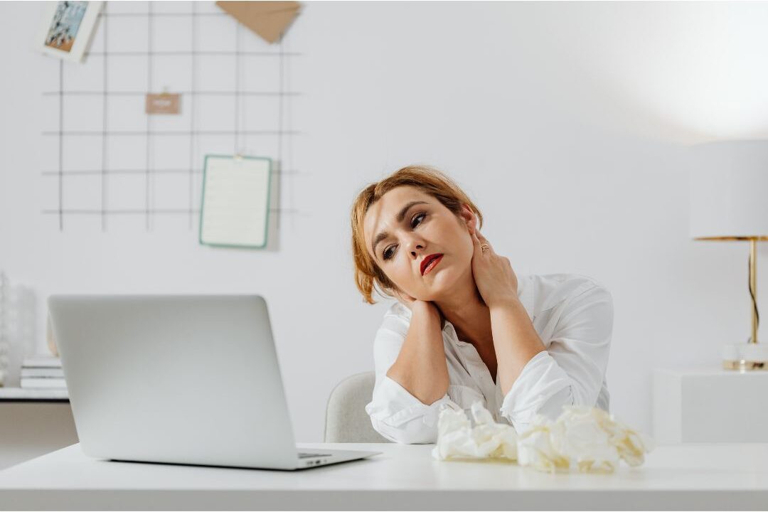 confused woman looking at her laptop suffering from brain fog