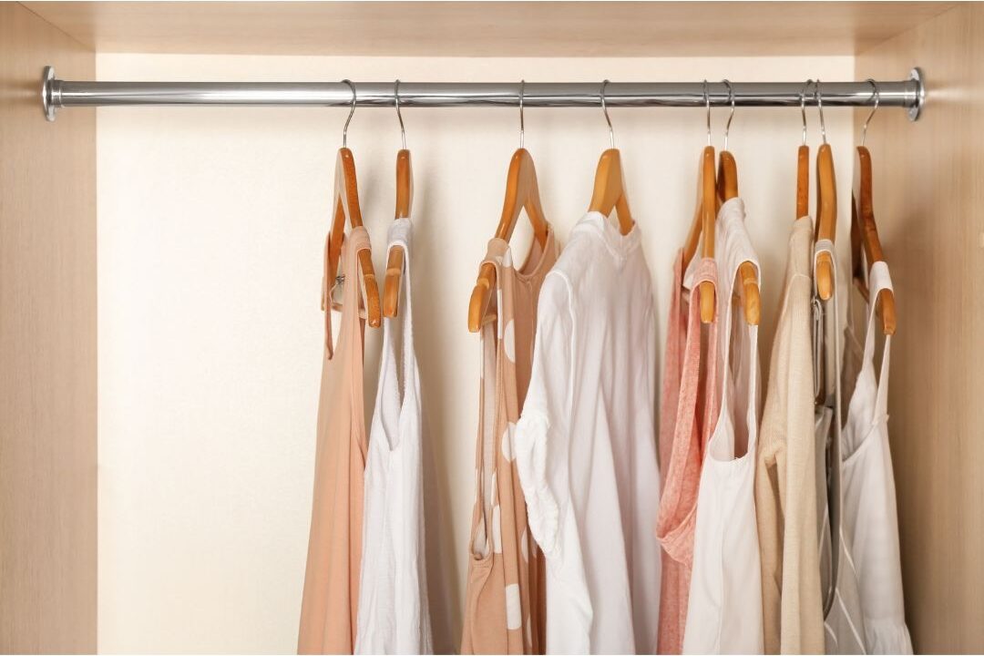 minimalist closet with clothes hanging neatly on wooden hangers showcasing home systems that practically run themselves