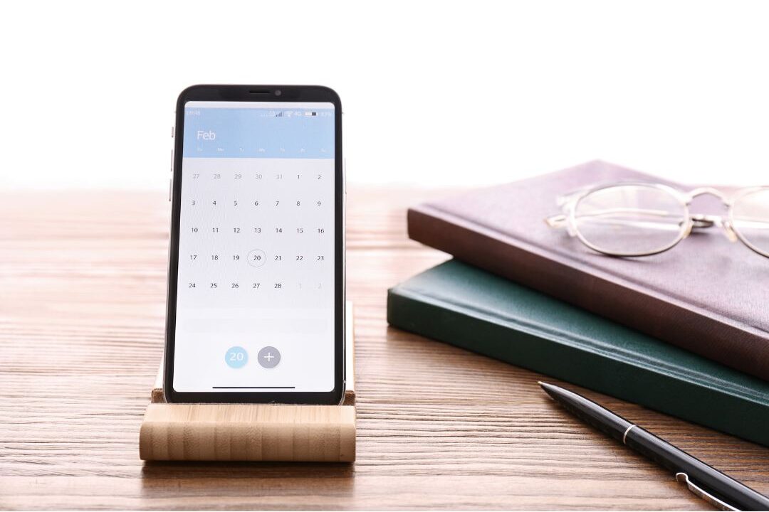 digital calendar on smartphone placed on clean table illustrating home systems that practically run themselves