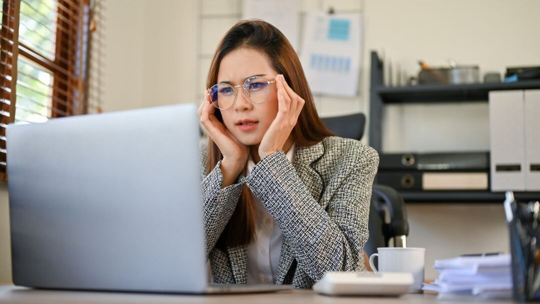woman looking confused at multiple browser tabs on a laptop screen illustrating why most moms never make money online