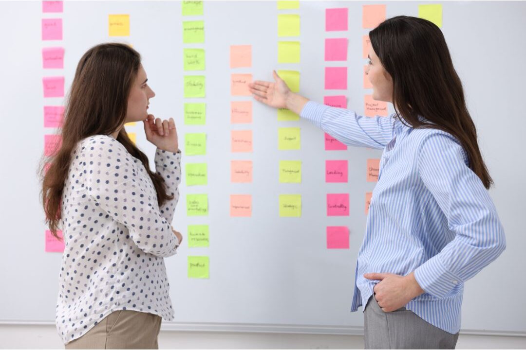 woman planning business strategies on a whiteboard with colorful sticky notes