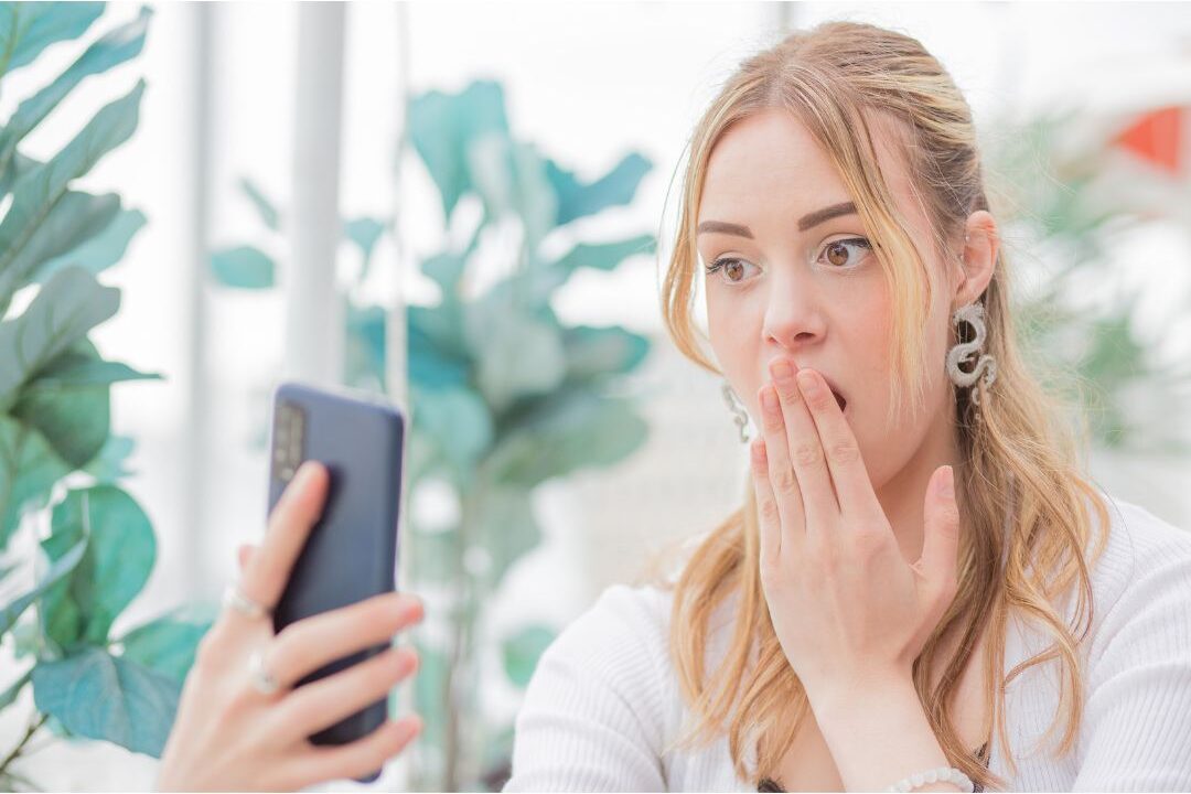 woman holding a smartphone looking at a cloud storage notification warning