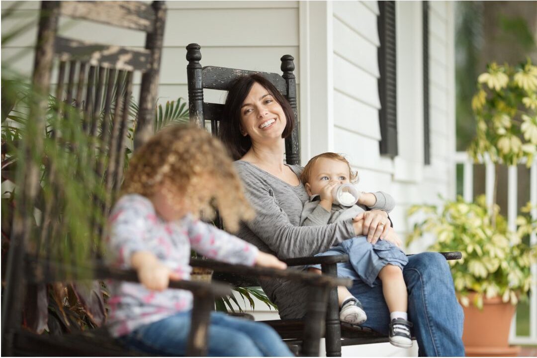 confident mother smiling sitting on a cozy porch enjoying financial peace of mind