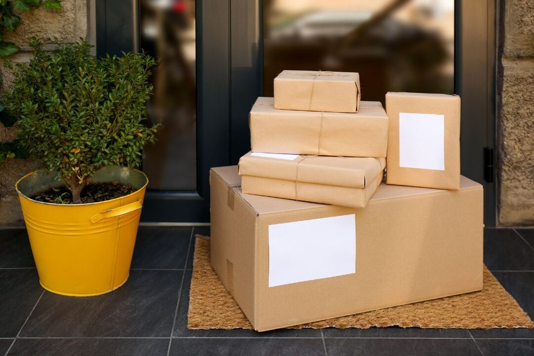 cardboard delivery boxes sitting on a front porch representing the hidden expenses quietly destroying your budget
