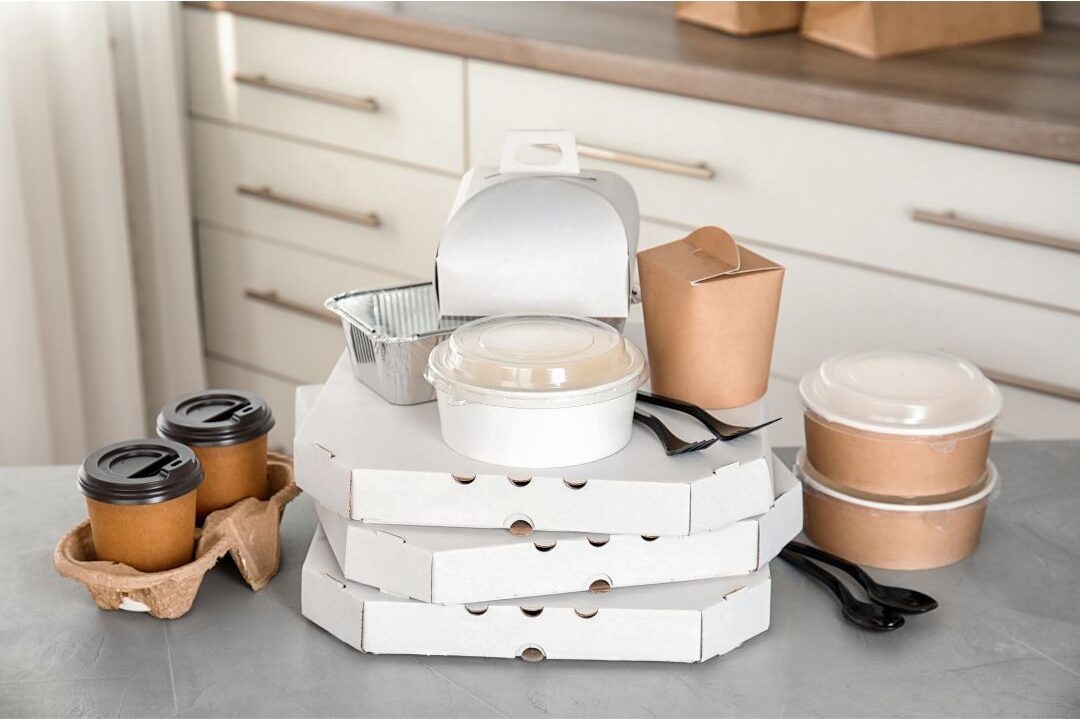 takeout food boxes on a kitchen island highlighting money mistakes stay-at-home moms make