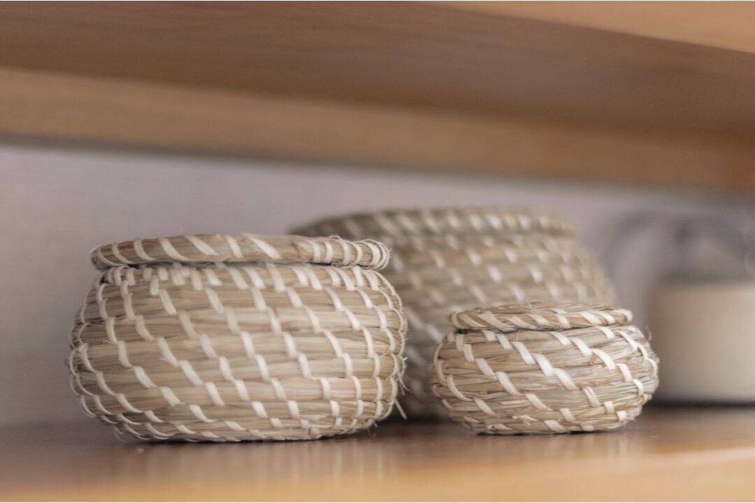 woven seagrass basket sitting neatly on clean wooden shelf eliminating decor mistakes that make homes look cluttered