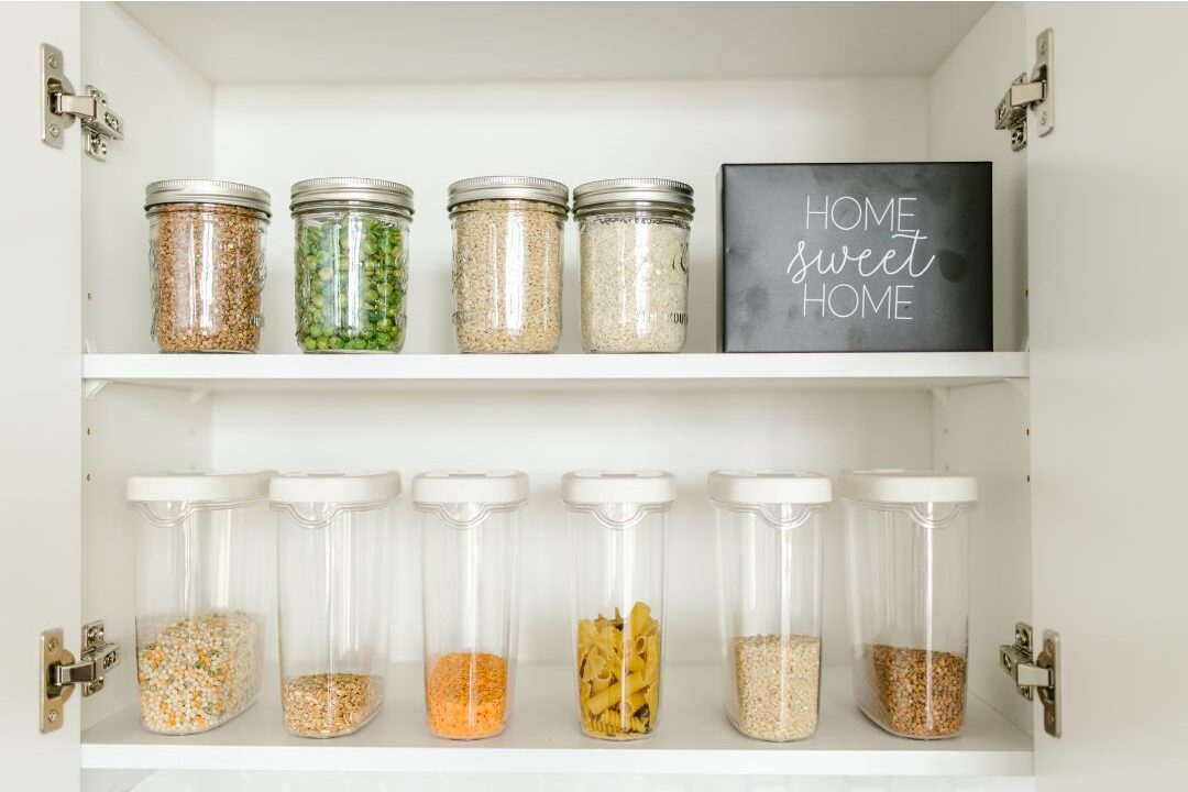 clear glass jars on organized pantry shelves with neat labels showing functional decluttering