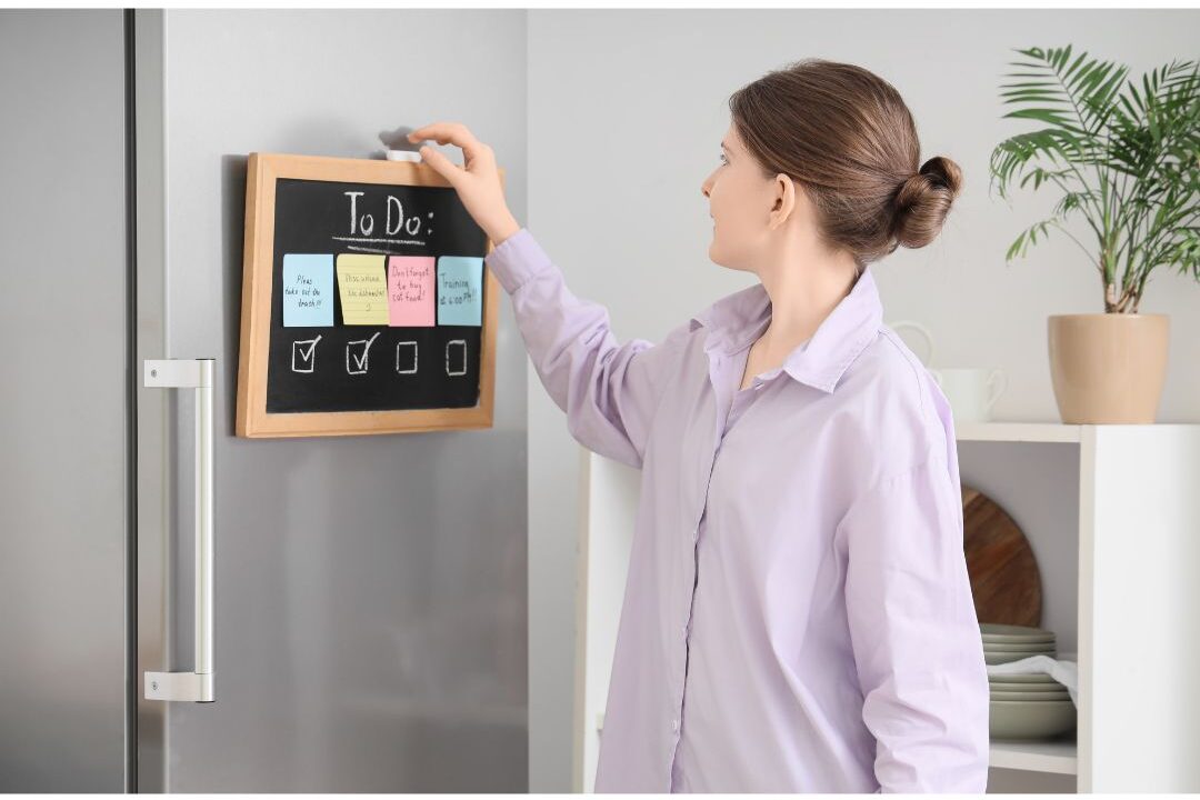 woman delegating household tasks on a family chalkboard exploring ways to feel like yourself again