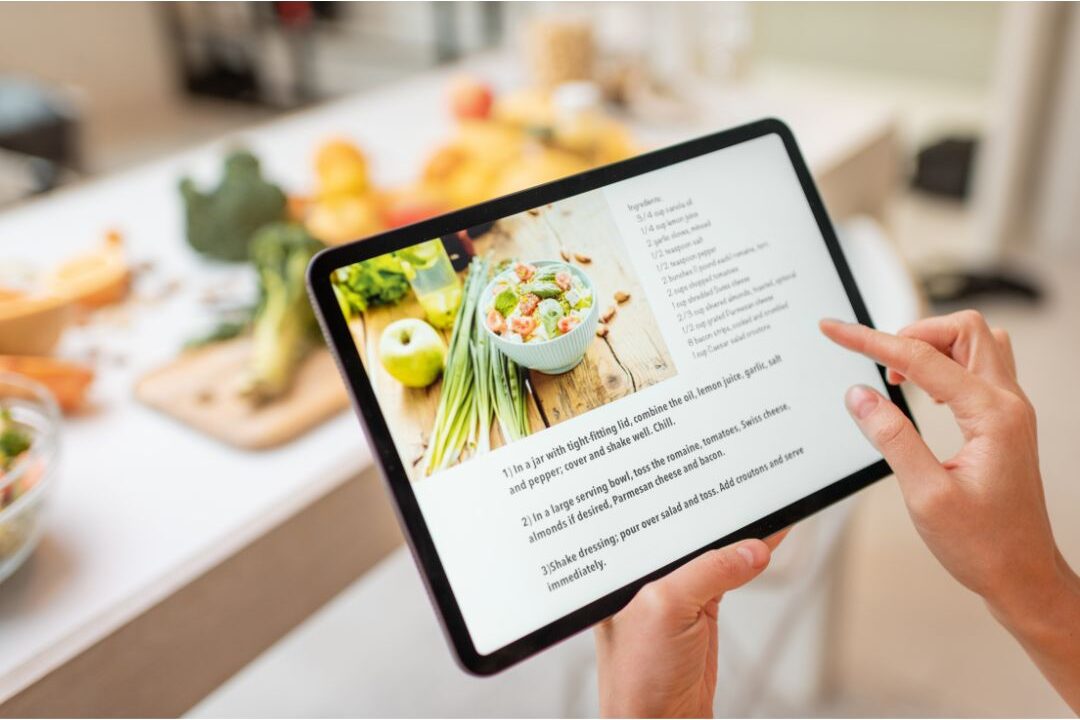 tablet displaying recipe app on kitchen counter near ingredients showing recipe archives