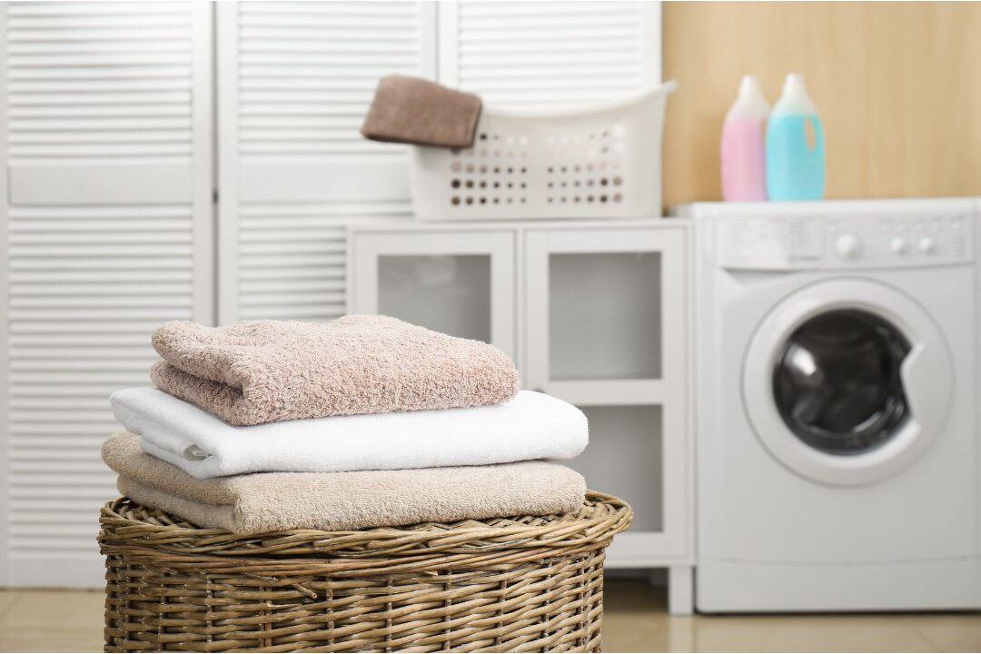 clean laundry basket with folded white towels in sunlit laundry room showing streamlined laundry systems