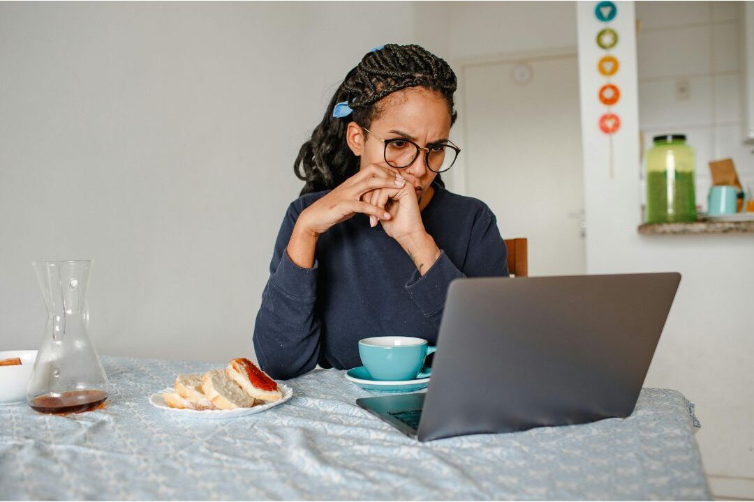 peaceful woman working on laptop at bright wooden table discovering the easiest digital products to sell this year