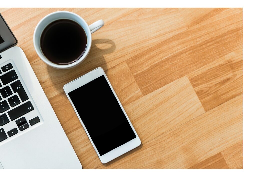 clean minimalist smartphone on wooden table next to warm tea cup using the systems that saved me 10 hours every week